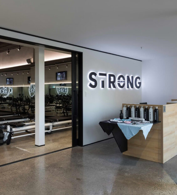 Modern Pilates studio entrance with equipment and signage.