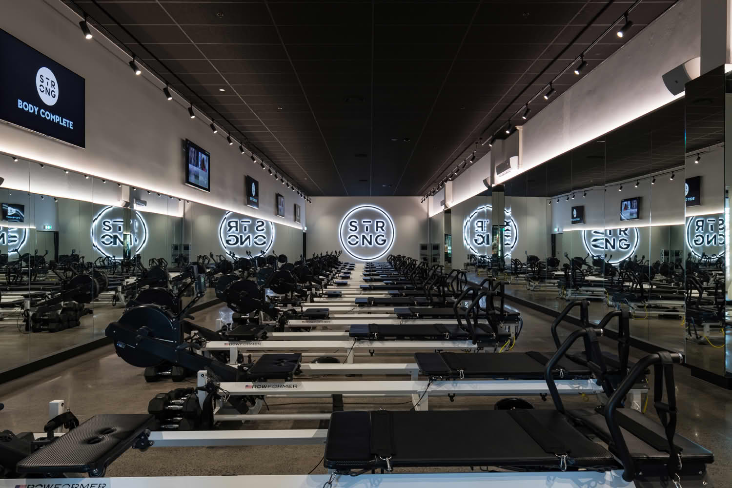 Modern gym with reformer machines and mirrors