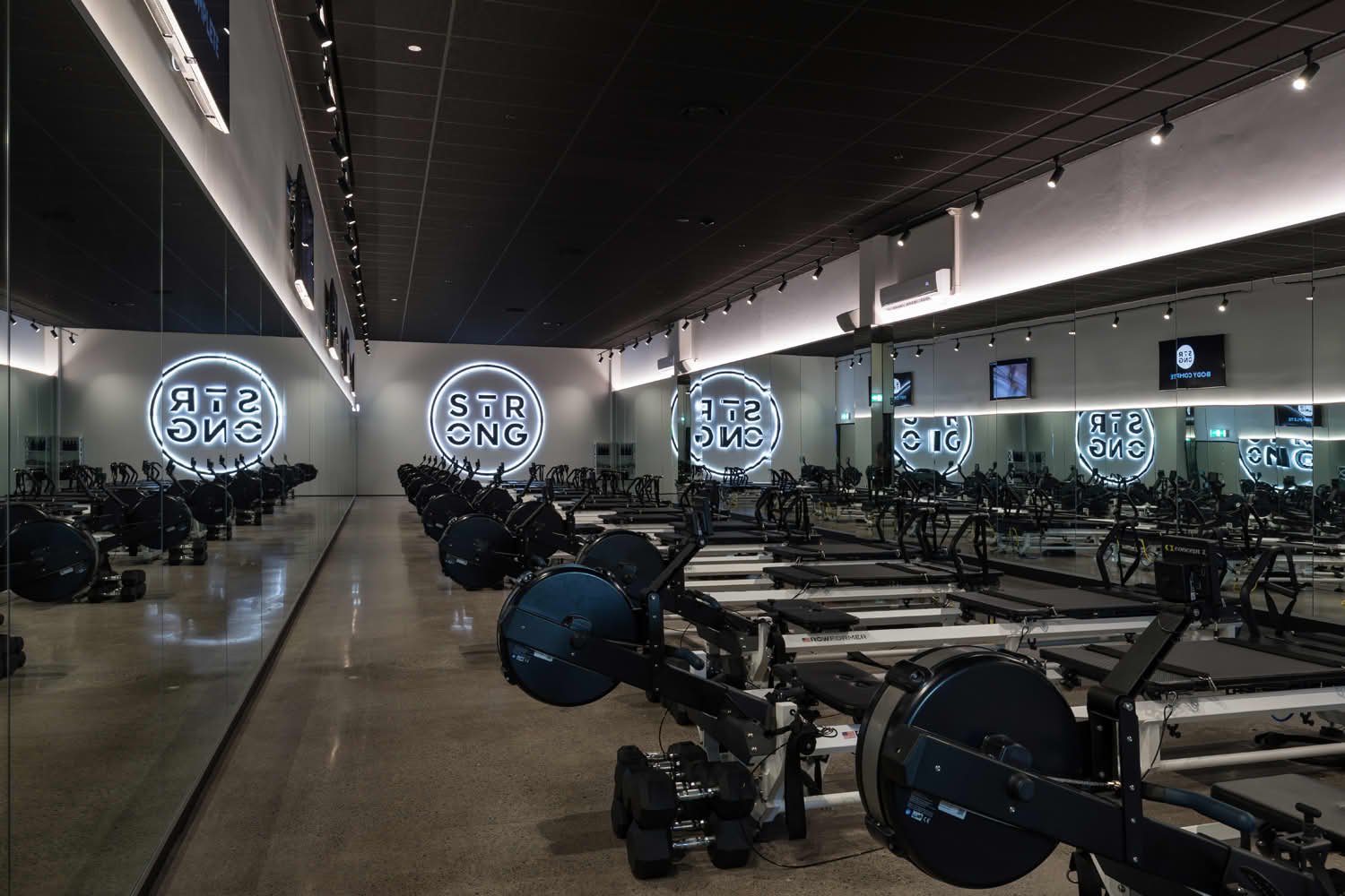 Modern gym with rowing machines and mirrored walls
