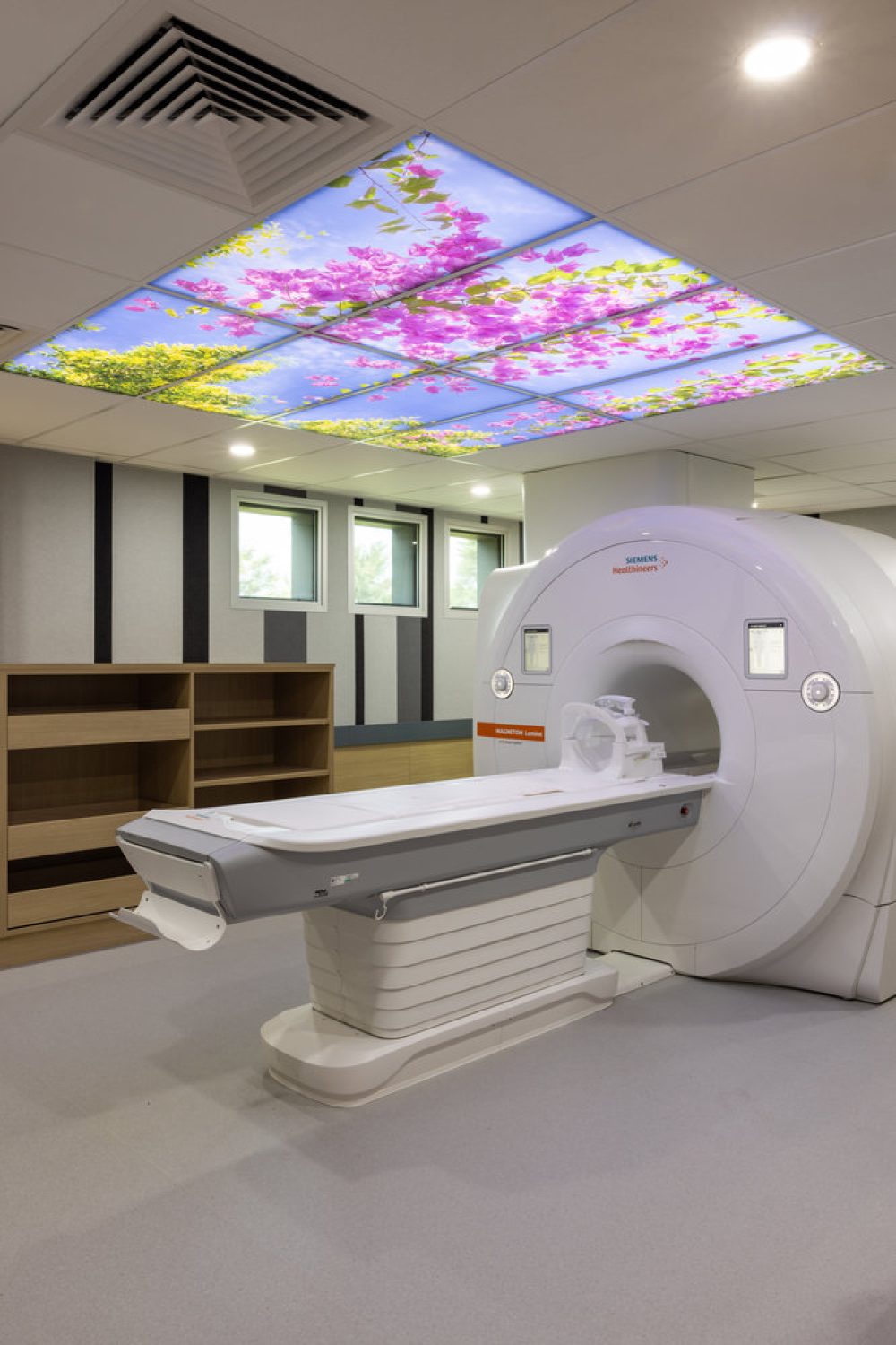 Modern MRI scanner in hospital room with floral ceiling